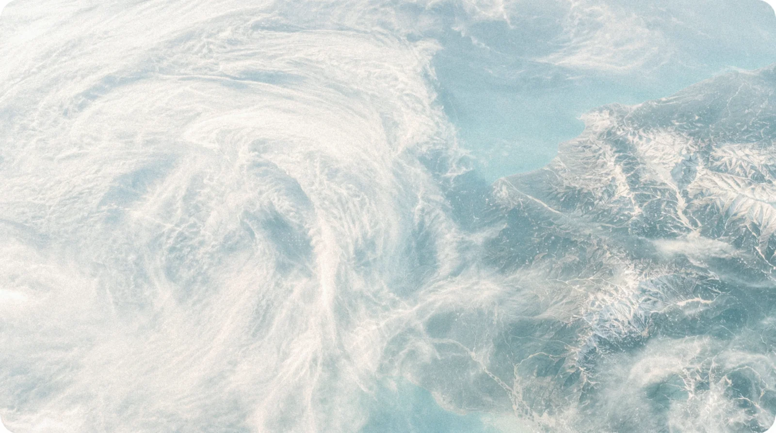 Satellite view of weather systems sweeping over coastline.